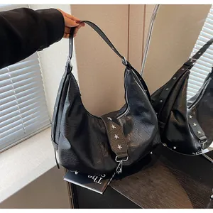 Detail of star-shaped metal studs and buckle on black leather hobo shoulder bag
