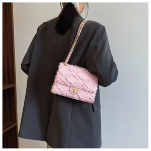 Sac bandoulière en tweed rose avec chaîne dorée et texture matelassée vue de profil