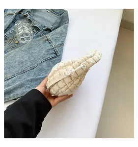 Détail du sac nuage crème avec texture matelassée à bulles et boucle de réglage sur la bandoulière