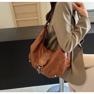 Detail view of caramel brown tote bag strap with silver star rivets and soft leather texture