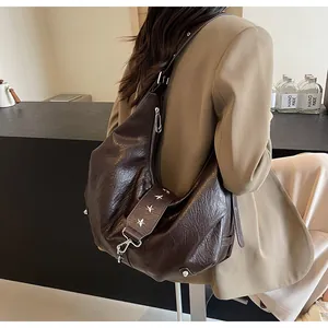 Detail of dark brown tote bag featuring silver star studs and premium pebbled leather