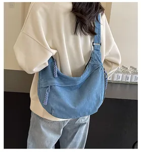 Détail du sac hobo en jean avec fermeture éclair tressée et large bandoulière réglable
