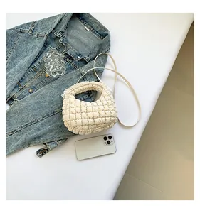 Détail du sac nuage matelassé blanc montrant la texture et la poignée ronde chic