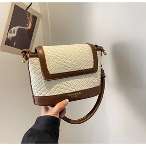 Détail du sac texturé bicolore avec garniture en cuir et lettrage doré de mode chic