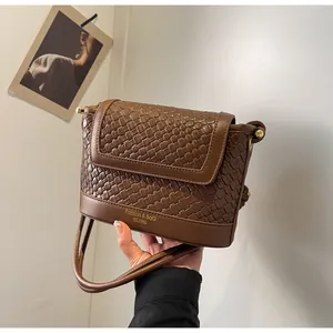 Détail du tissage sur ce sac bandoulière marron avec des finitions métalliques dorées