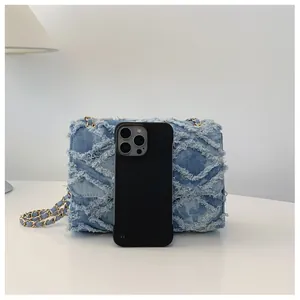 Détail du sac en jean avec texture matelassée et smartphone pour référence de taille