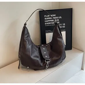 Detail of vintage brown leather hobo bag with silver star rivets and adjustable buckle