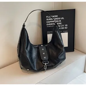 Close-up of black leather hobo bag with silver star rivets and metal swivel hook detail
