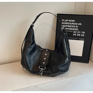 Detail of vintage black hobo bag featuring silver star studs and textured faux leather
