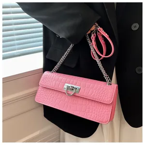 Detailed view of pink crocodile pattern leather bag with silver metal chain and lock