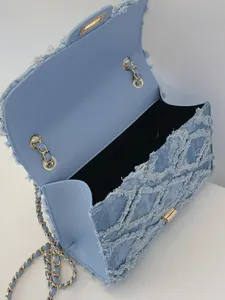 Sac bandoulière en denim bleu clair avec texture matelassée et chaîne dorée