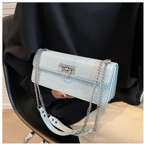 Detail of light blue crocodile embossed leather texture with silver metal clasp and chain