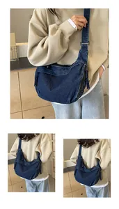 Détail du sac bandoulière en denim avec coutures blanches et tirette tressée