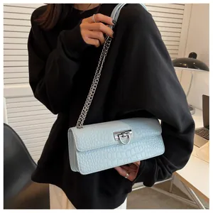 Detail of light blue crocodile pattern small square bag with silver metal chain strap