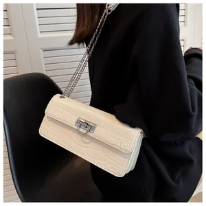 Detail of white crocodile pattern shoulder bag with silver chain strap and metallic lock