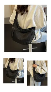 Détail du sac bandoulière en denim noir avec surpiqûres blanches et glands en cordon tressé