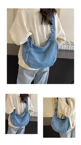 Détail du sac croissant en jean bleu clair avec tirette tressée pour un style décontracté