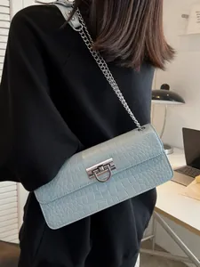 Light blue faux crocodile leather crossbody bag with silver chain strap on model