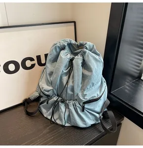 Detail view of the drawstring nylon backpack with side zipper pockets and pleated texture