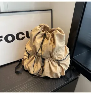 Detail view of the drawstring closure and durable nylon texture on a khaki backpack