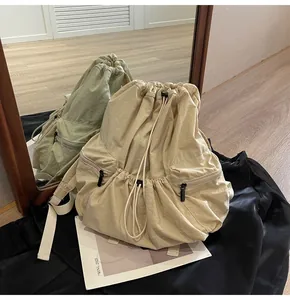 Detailed mirror reflection of cream nylon backpack featuring drawstring closure and zip pockets