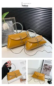 Detail showing yellow glossy leather shoulder bag with rhinestone ring handle and chain