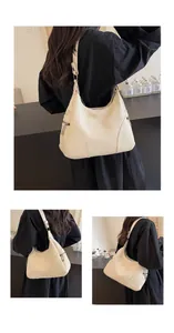 Detail of off-white lychee grain leather hobo bag with silver zipper and side texture