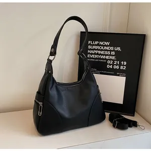 Close-up of black lychee texture bag with paperclip zipper and side pocket details