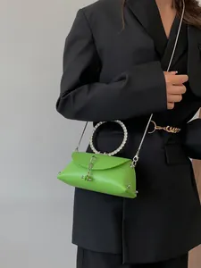Green rhinestone ring handle crossbody bag with metallic chain on black blazer model