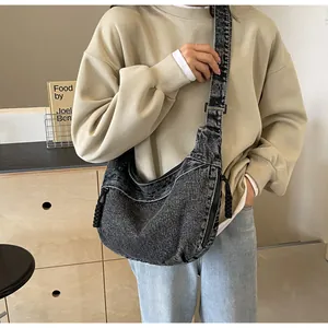 Détail du sac bandoulière croissant en jean délavé gris avec tirette de zip en cordon