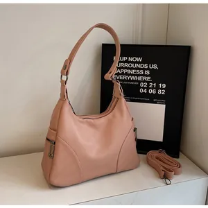 Detail of pink hobo bag with lychee texture, zip pockets and adjustable strap