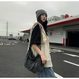 Deep grey washed denim messenger bag featuring functional side pockets in a street style