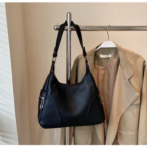 Detail of black lychee grain leather hobo bag with silver zipper and metal buckle
