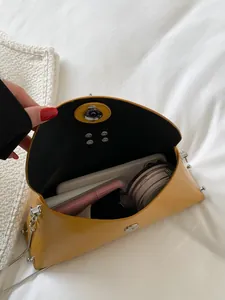 Yellow envelope handbag with diamond ring and chain strap showing daily storage capacity