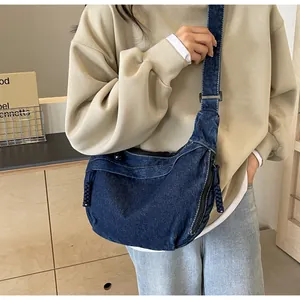 Détail du sac croissant en denim bleu foncé avec surpiqûres blanches et fermeture en corde