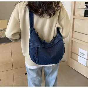 Détail du sac bandoulière en jean bleu foncé avec bordure en corde sur mannequin