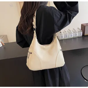 Close-up of off-white lychee grain leather hobo bag featuring silver side zippers