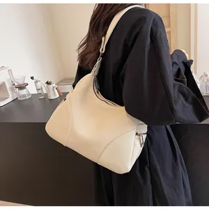 Close-up of off-white lychee grain leather shoulder bag with sleek silver zipper detail