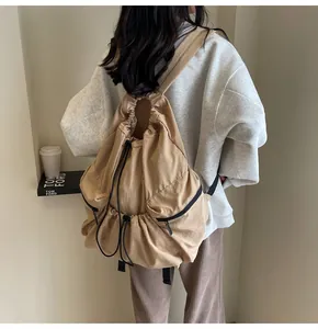 Close-up of khaki drawstring backpack featuring durable nylon fabric and side zipper pockets