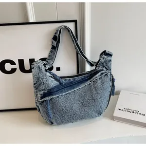 Détail du sac lune en denim délavé bleu avec tirette de fermeture en corde tressée