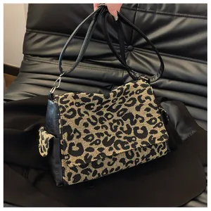 Detail van luipaardprint crossbodytas met zwarte lederen klep en verstelbare riem