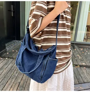 Macro view of large blue denim hobo bag featuring a side pocket and vintage wash texture
