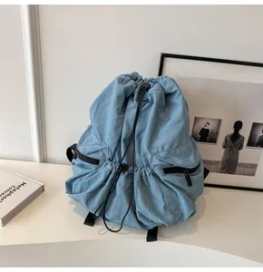 Close-up of light blue nylon backpack featuring a functional drawstring closure design