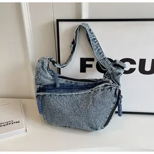 Détail du sac à main en denim délavé bleu clair avec tirette de fermeture tressée