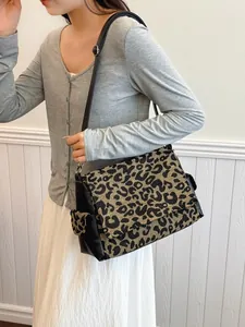 Luipaardprint crossbody tas met verstelbare riem gedragen door model op witte achtergrond