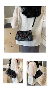Detail van zwarte plissé cloud bag met barnsteen kralenketting en zacht mat PU-leder