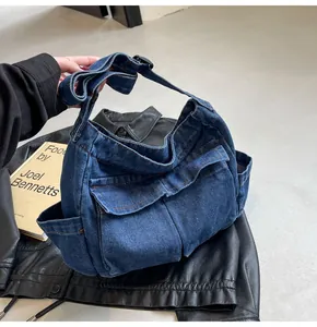 Close-up of deep blue denim tote bag with cargo pockets and contrast orange stitching