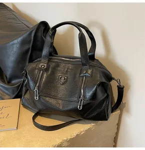 Detail view of black faux leather Boston bag with silver hardware and double zippers