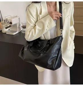 Detail of black large capacity tote bag with adjustable strap and silver hardware