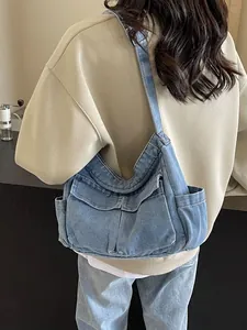 Retro denim tote bag featuring dual front flap pockets and side pouches on a model